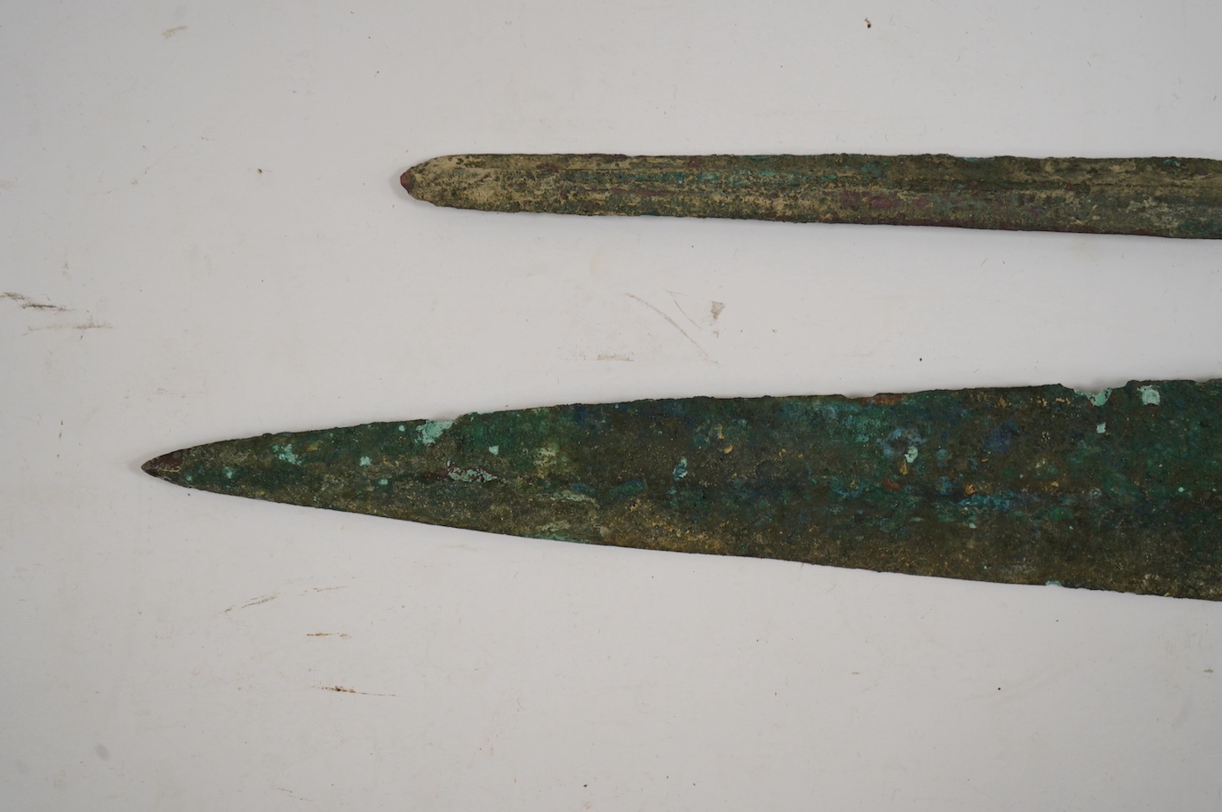 Two assorted Bronze Age spearheads, one of leaf shape with turned over tang, the other short with narrow blade. Condition - poor to fair.